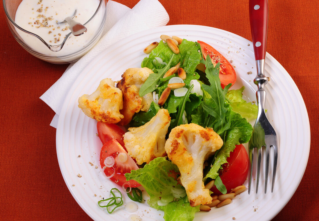 Close-up of green salad with roasted cauliflower on plate 