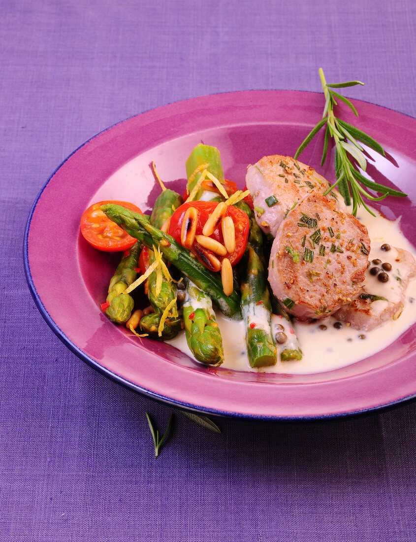 Close-up of pork fillet with green asparagus salad on plate 