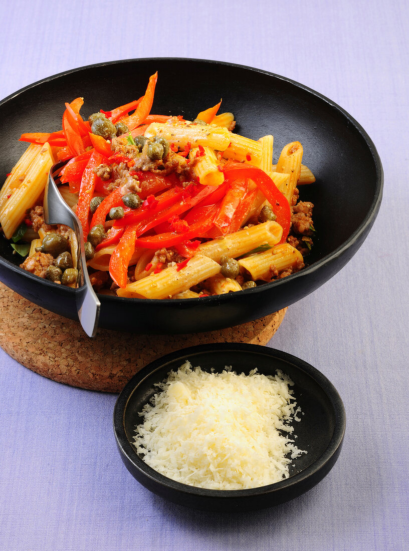 Pasta with ragu, paprika and capers in bowl 