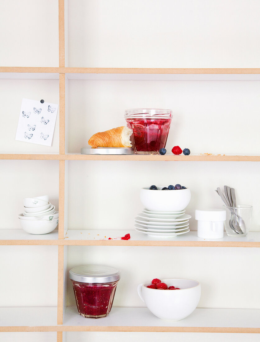 Blueberry and raspberry jam in glass jar on the shelf