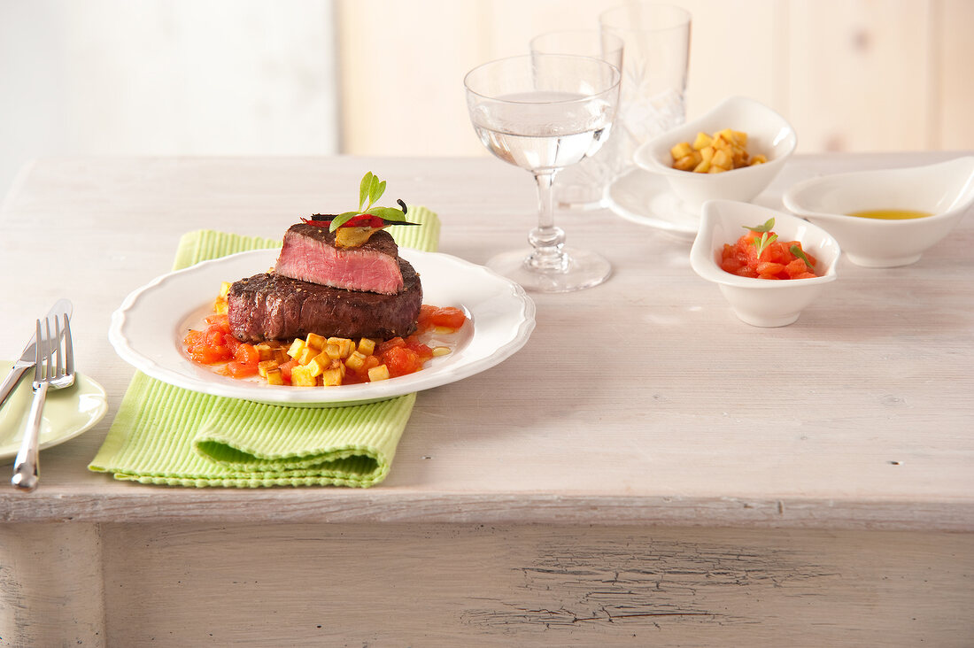 Beef tenderloin steaks with tomatoes and tarragon on plate