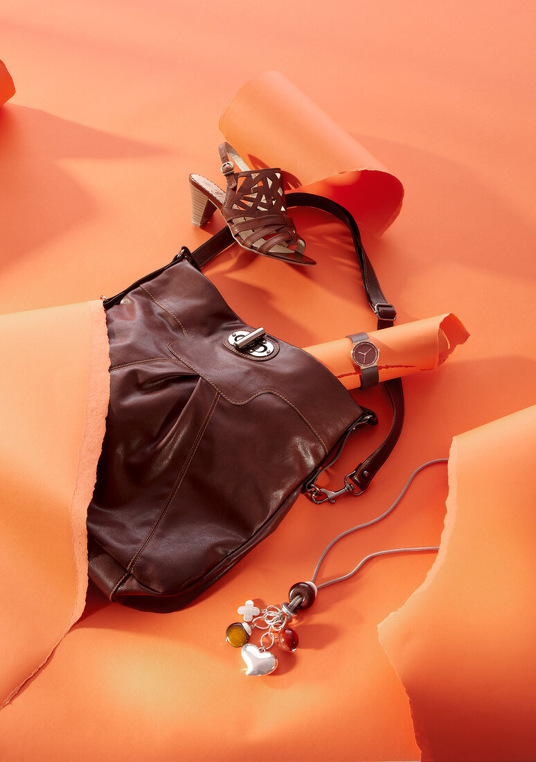 Shoes, bag, clock, chain in Kenya style on orange background