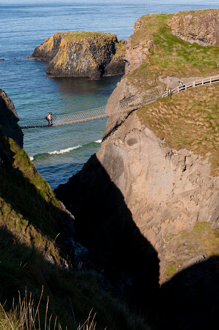 Irland: Antrim-Küste, Felsen, Meer, Carrick-a-Rede-Bridge, Wanderer.