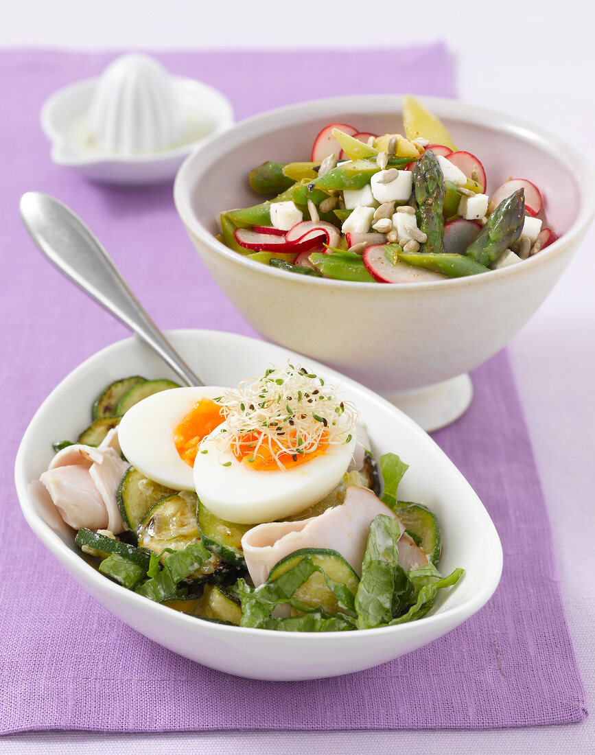 Vegetable salad with egg and warm asparagus salad in bowls