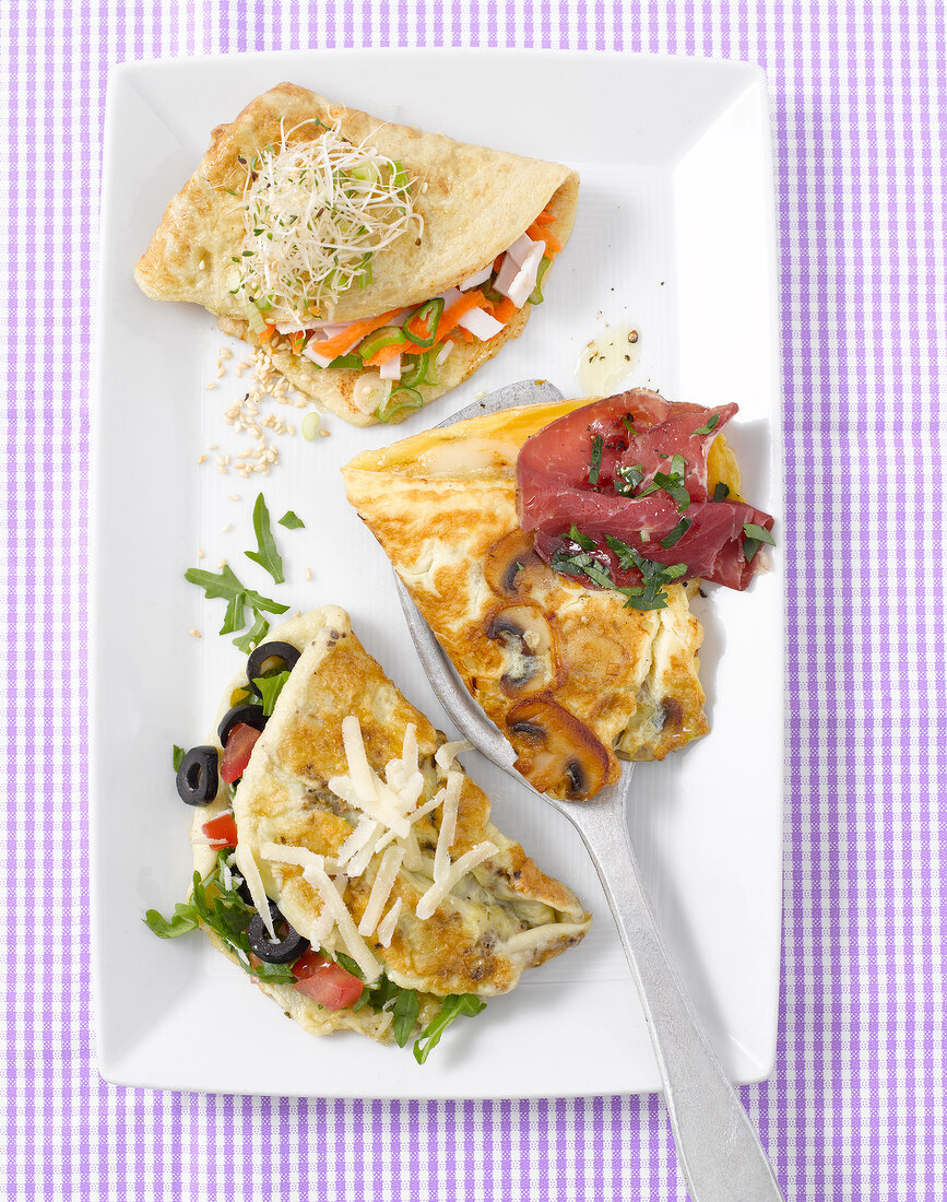 Three different omelettes on tray