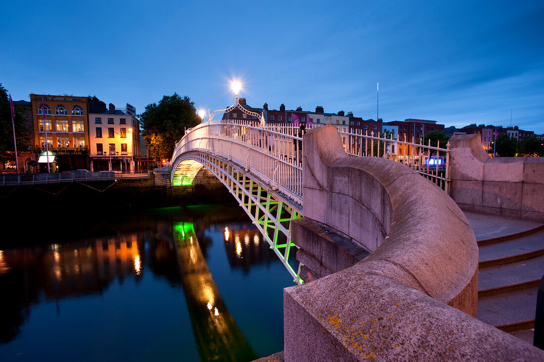 Illuminated Ha'penny Bridge over the Liffey River at night, Dublin, Ireland, UK