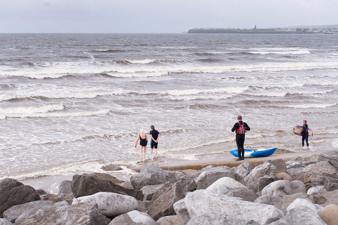 View of surfers and rocks at Lahinch Co Clare beach, Ireland, UK