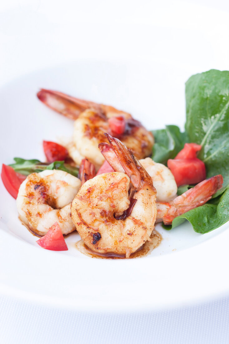 Close-up of shrimp with peppers and arugula on dish