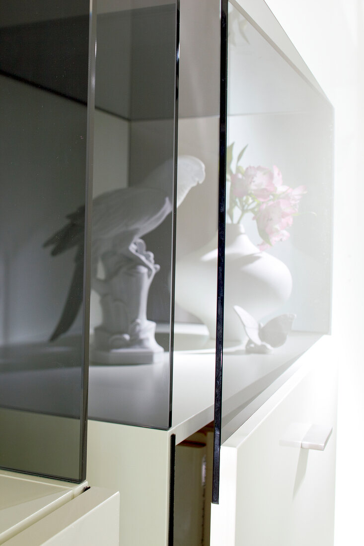Porcelain bird and vase behind glass