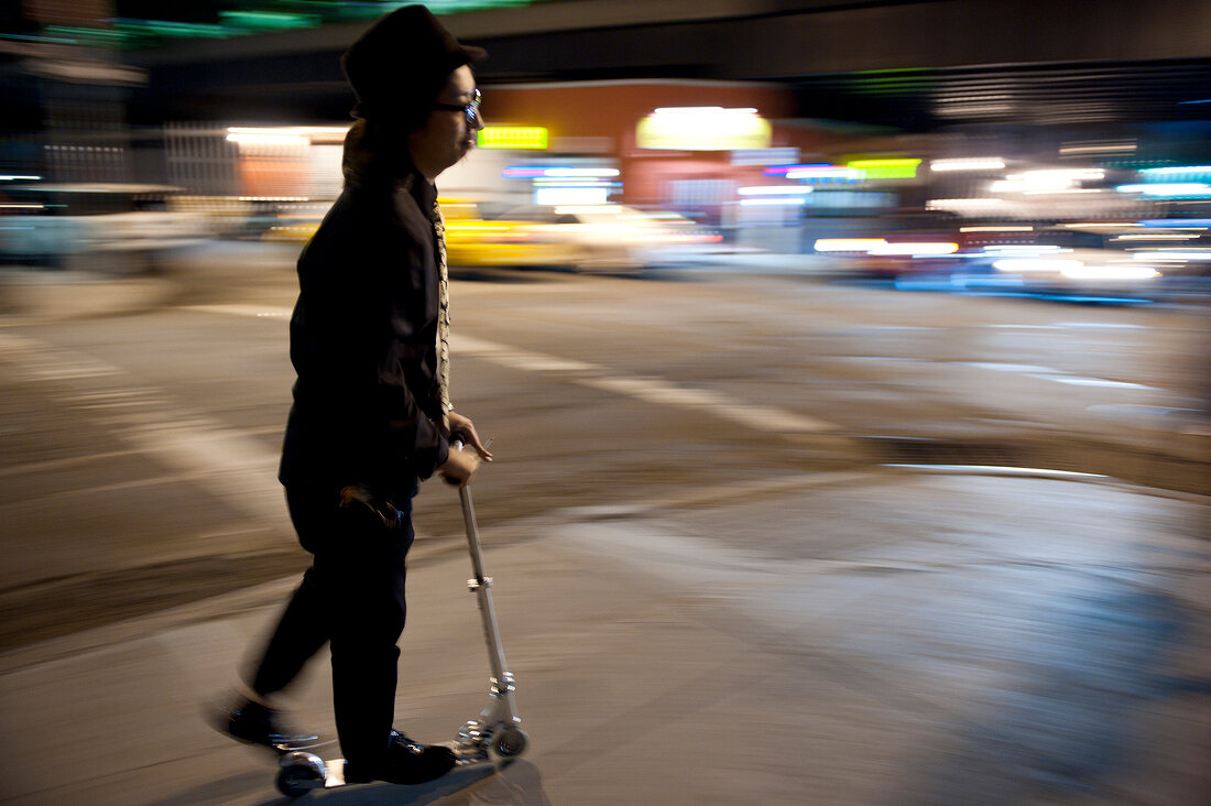 Man riding scooter in New York, USA, blurred motion