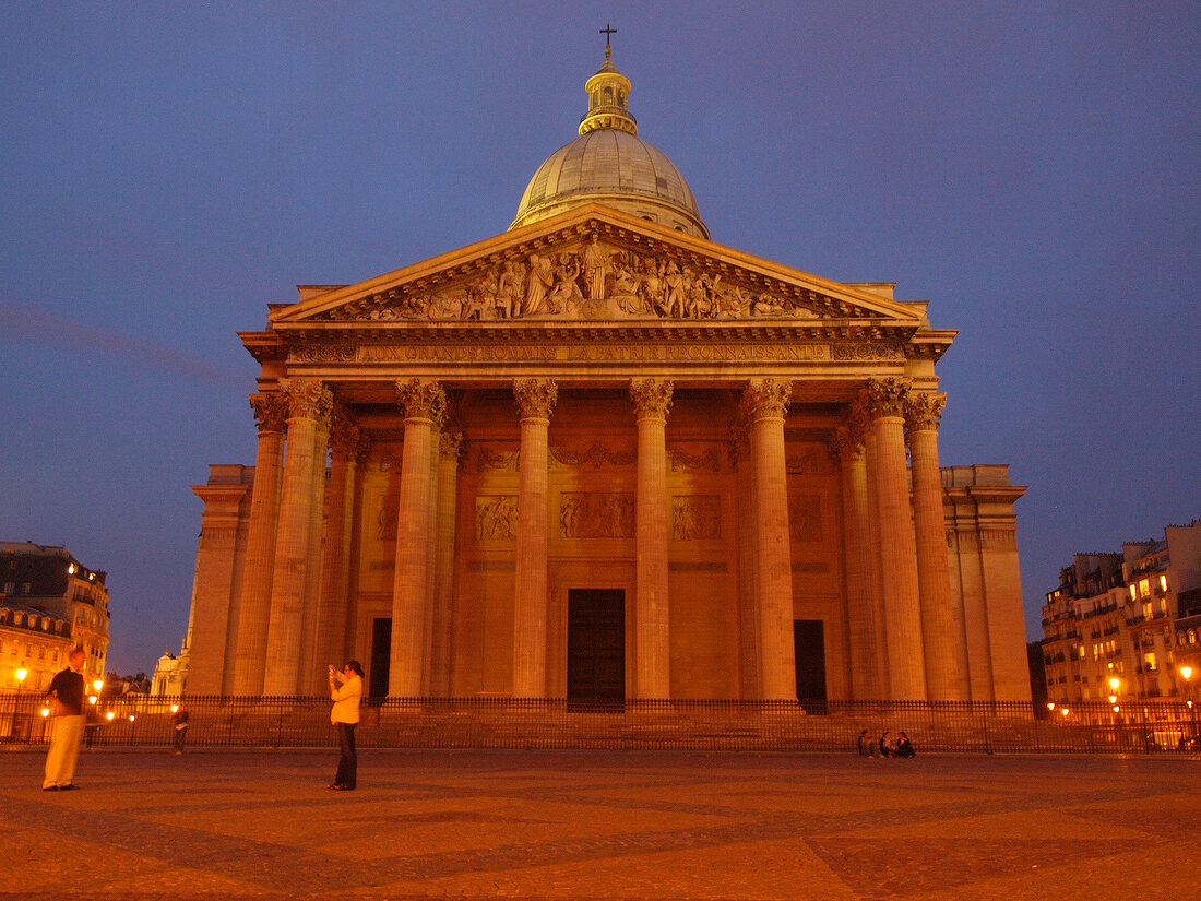 Illuminated facade of Pantheon dome and columns at night in Paris, France