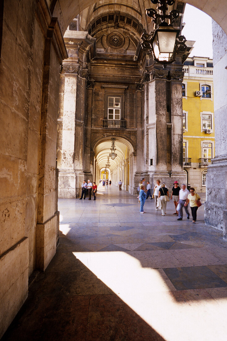 Tourist at Arco de Victoria triumphal arch in Lisbon, Portugal