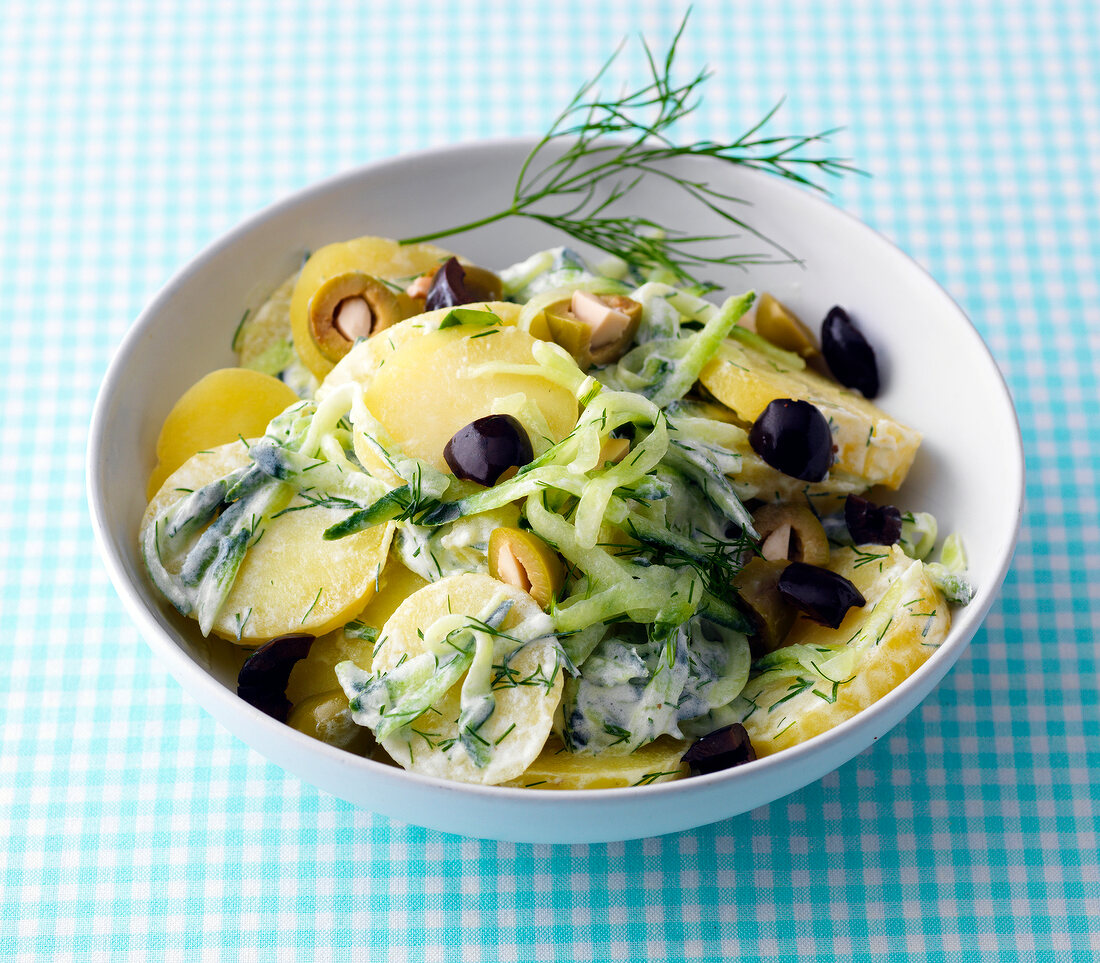 Potato salad with cucumber and olives in bowl