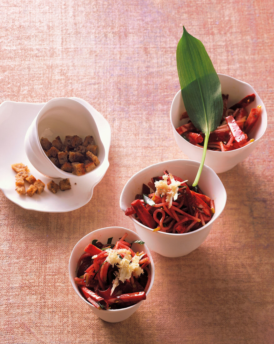 Beet salad with blood sausage and wild garlic oil in bowls