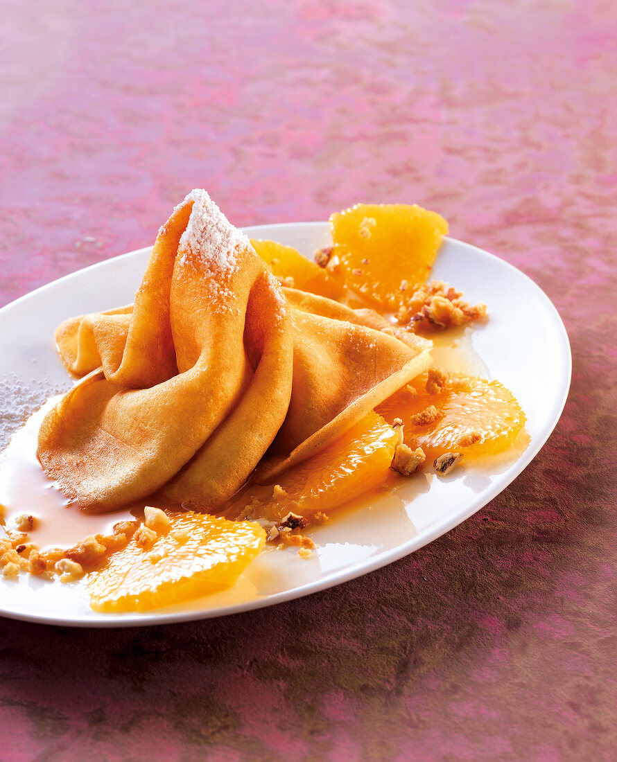 Caramel oranges with crepes on plate
