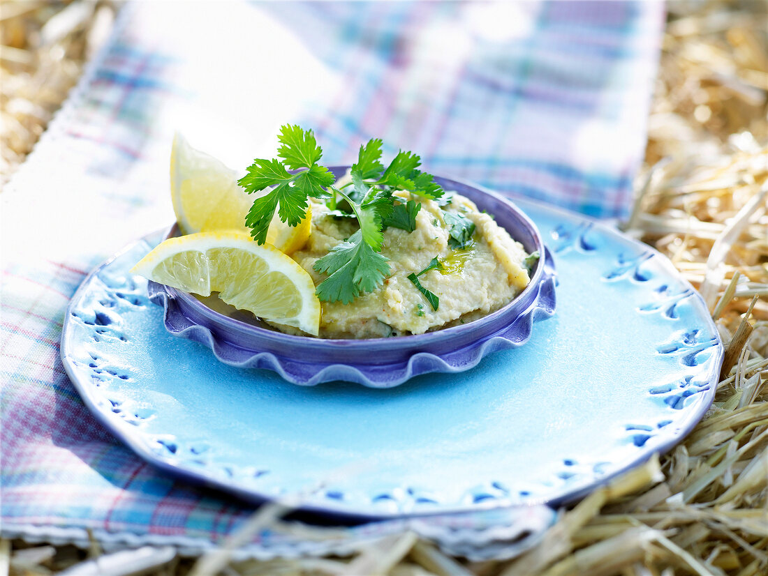 Oriental mashed peas with slice of lemon in saucer