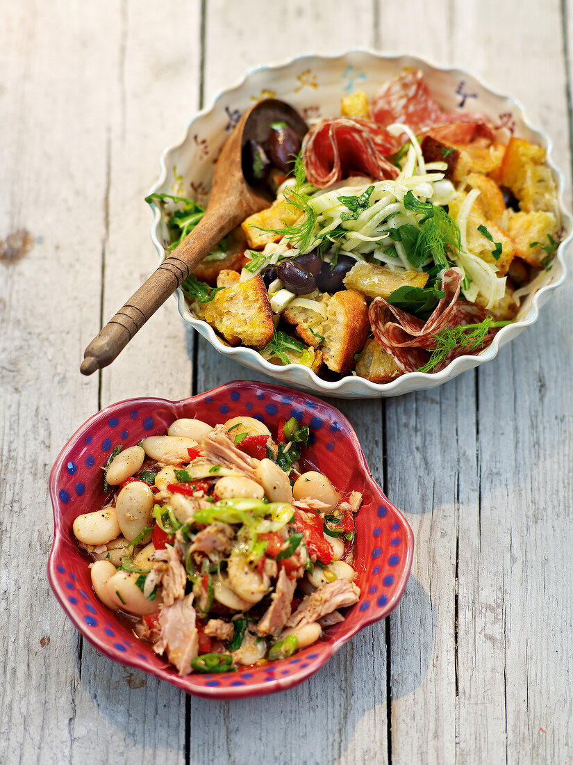 Bread salad and white bean salad with tuna in bowls in summer kitchen