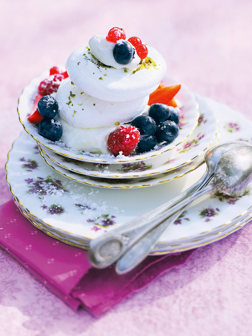 Swiss meringue with berries and cream on plate in summer kitchen