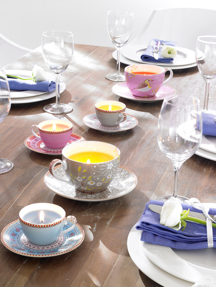Table setting with lit candles in collector's cups