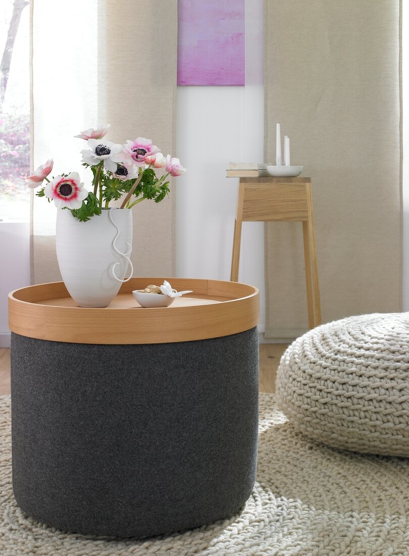 Flower vase in wooden tray on sito stool with wool cover