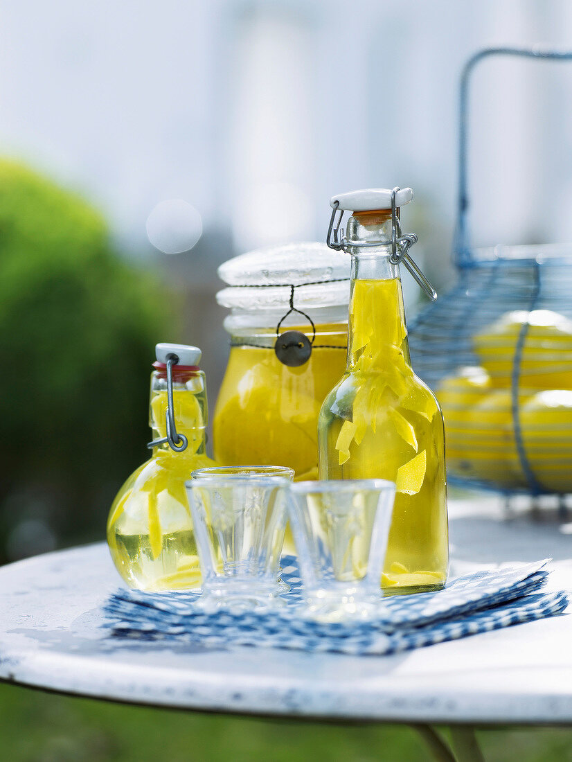Limoncello and pickled salted lemons in bottles in summer kitchen