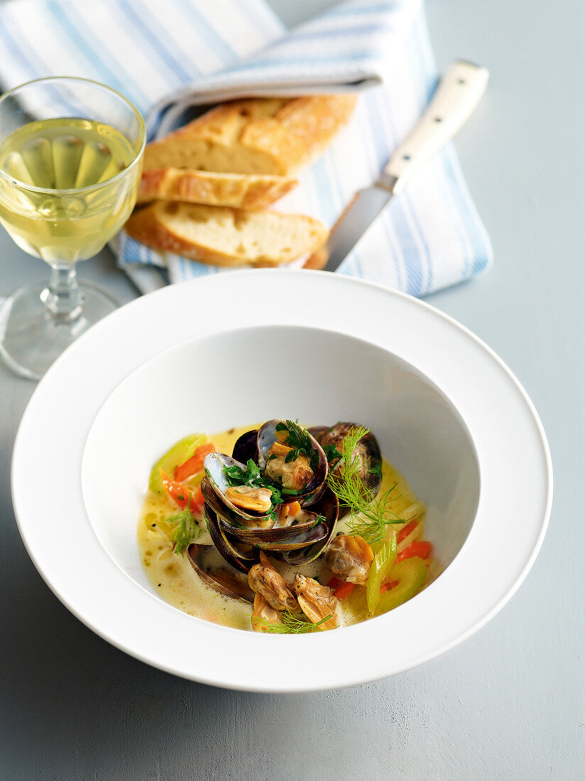 Classic clams with anissud in bowl and glass of white wine