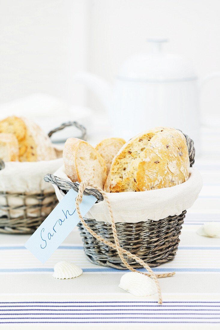 A bread basket with a name tag on a striped table runner