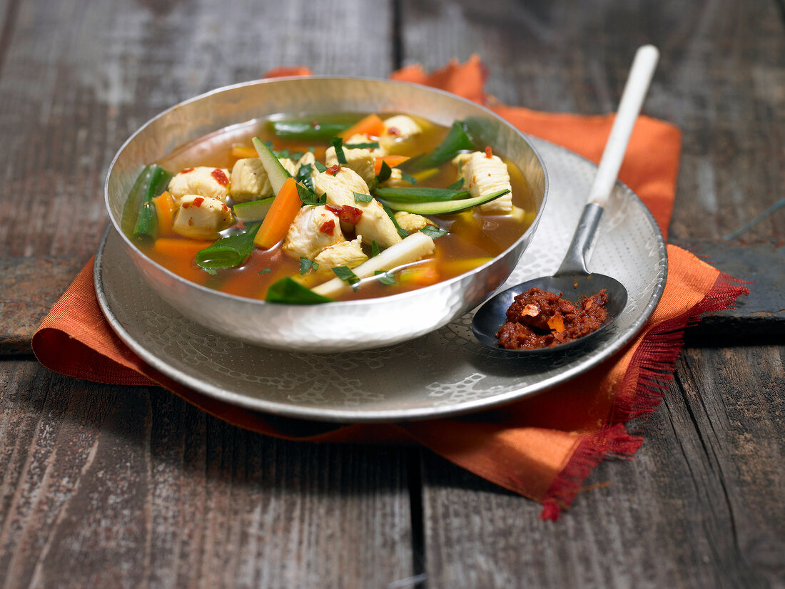 Oriental chicken soup with vegetables in bowl
