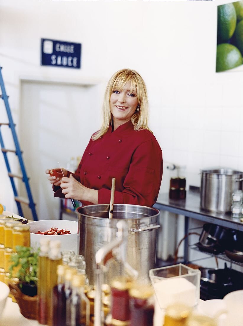 Portrait of marmalade cook Stefanie Kleinjung cutting strawberries