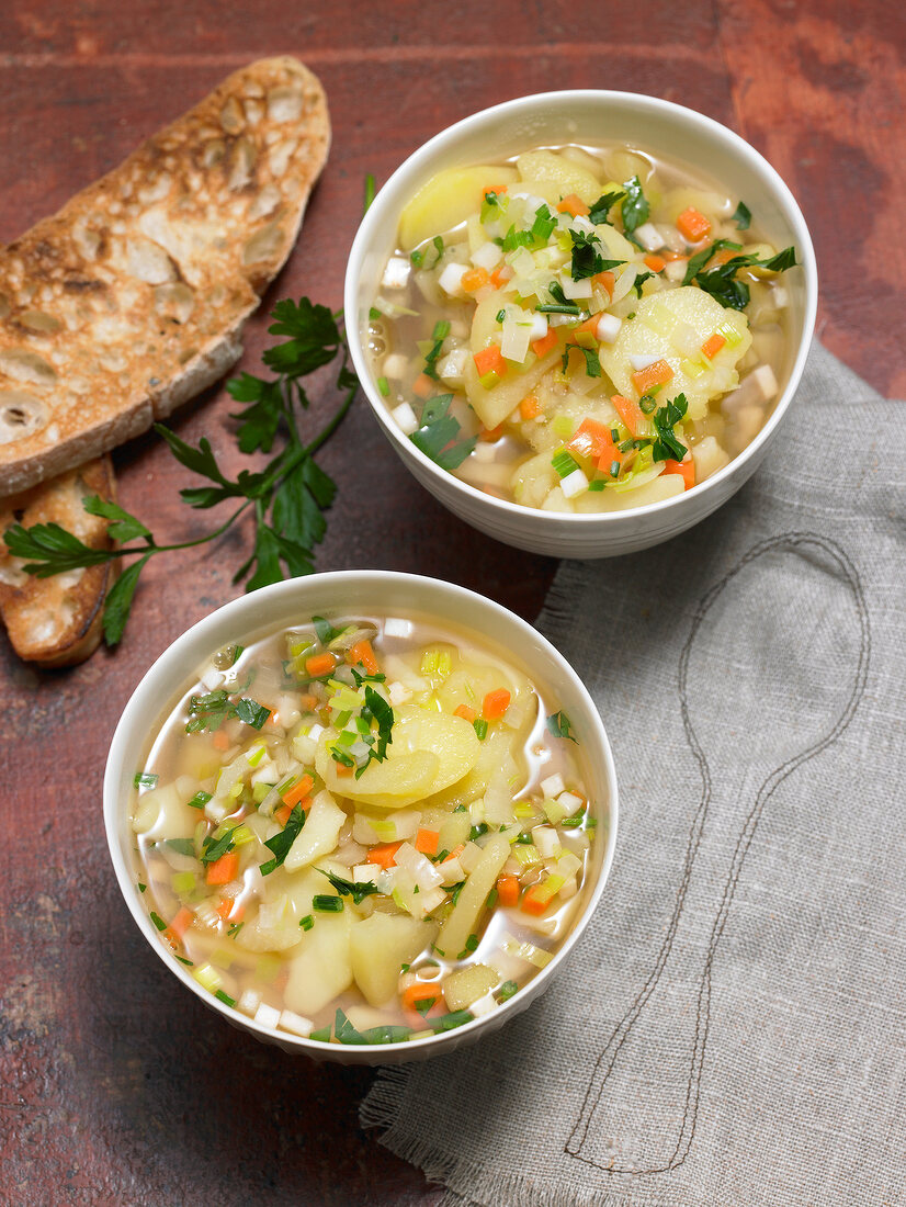 Two bowls of potato soup with vegetables