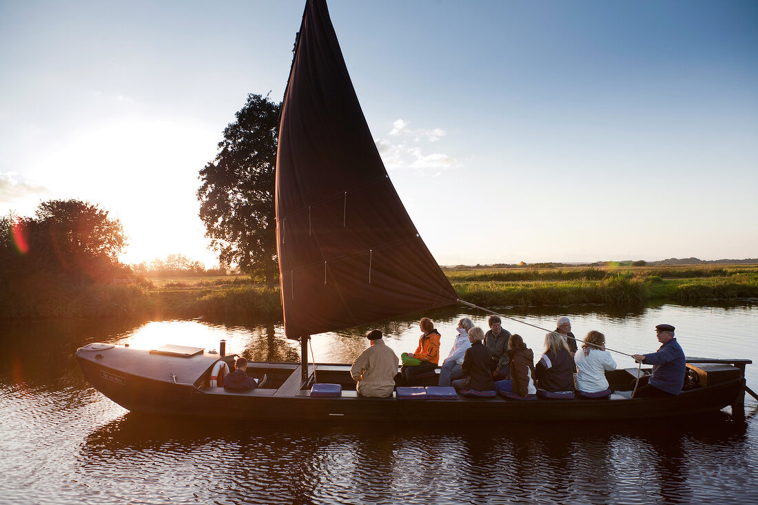 Tourists enjoying on sailboat at sunset in Worpswede, Lower Saxony, Germany