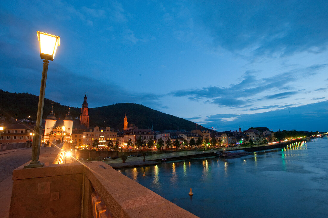 Illuminated Karl Theodor Bridge overlooking river Neckar at night in Heidelberg, Germany