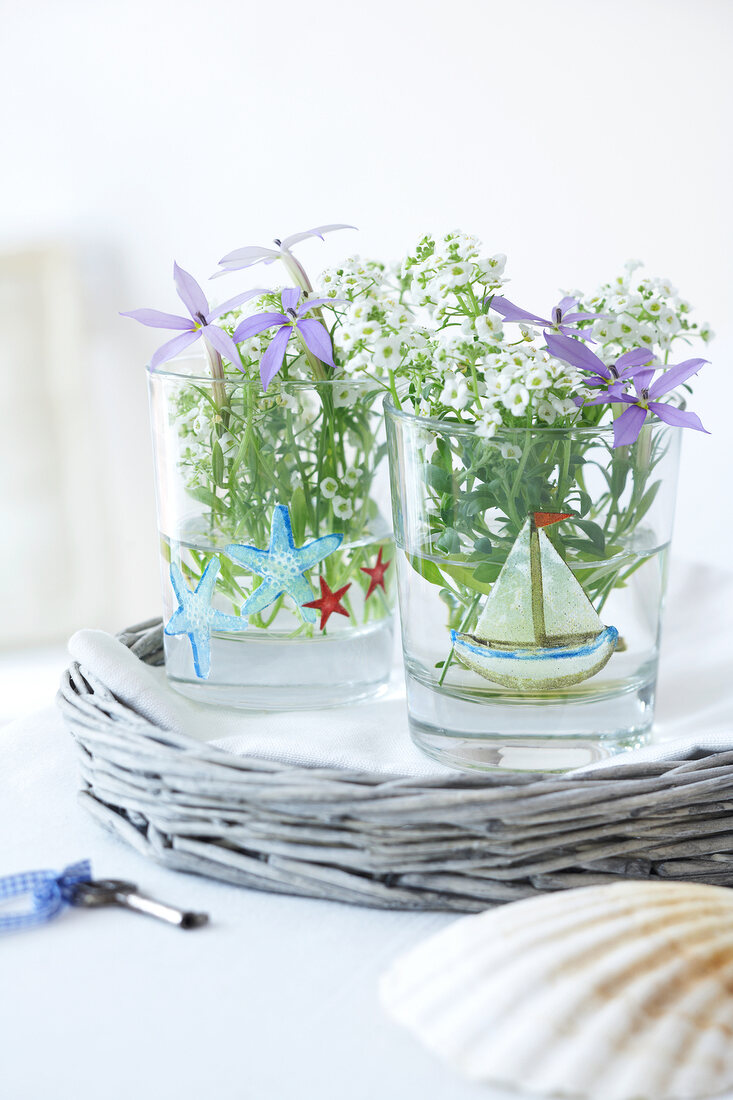 Flowers in decorated glasses with decoupage on table