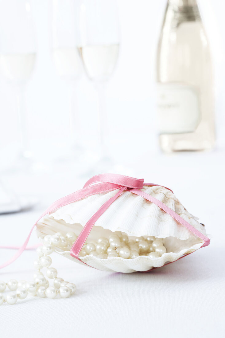 Pearl necklace in sea shell wrapped with pink ribbon