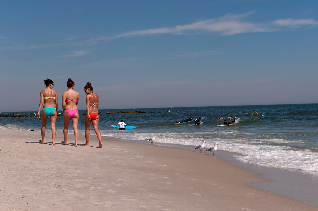 Rear view women wearing bikini and walking on Long Beach Island, New York, USA