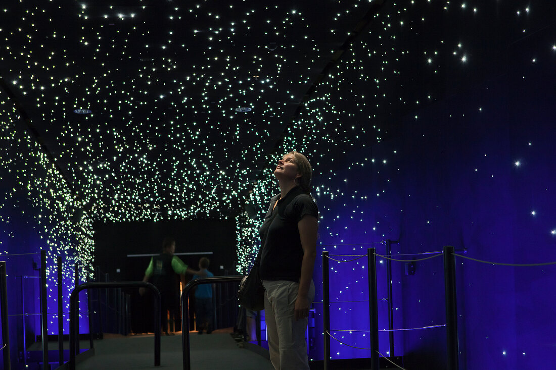 Visitor standing and looking up at starry sky in Climate House, Bremerhaven, Germany