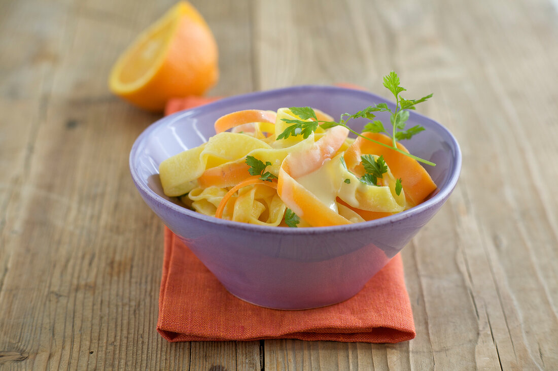 Ribbon pasta with carrot and parsley in bowl