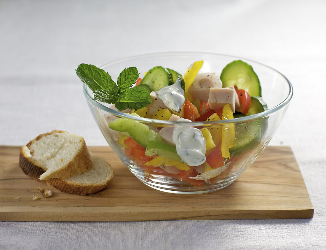 Salad with turkey breast, cucumber and pepper in glass bowl