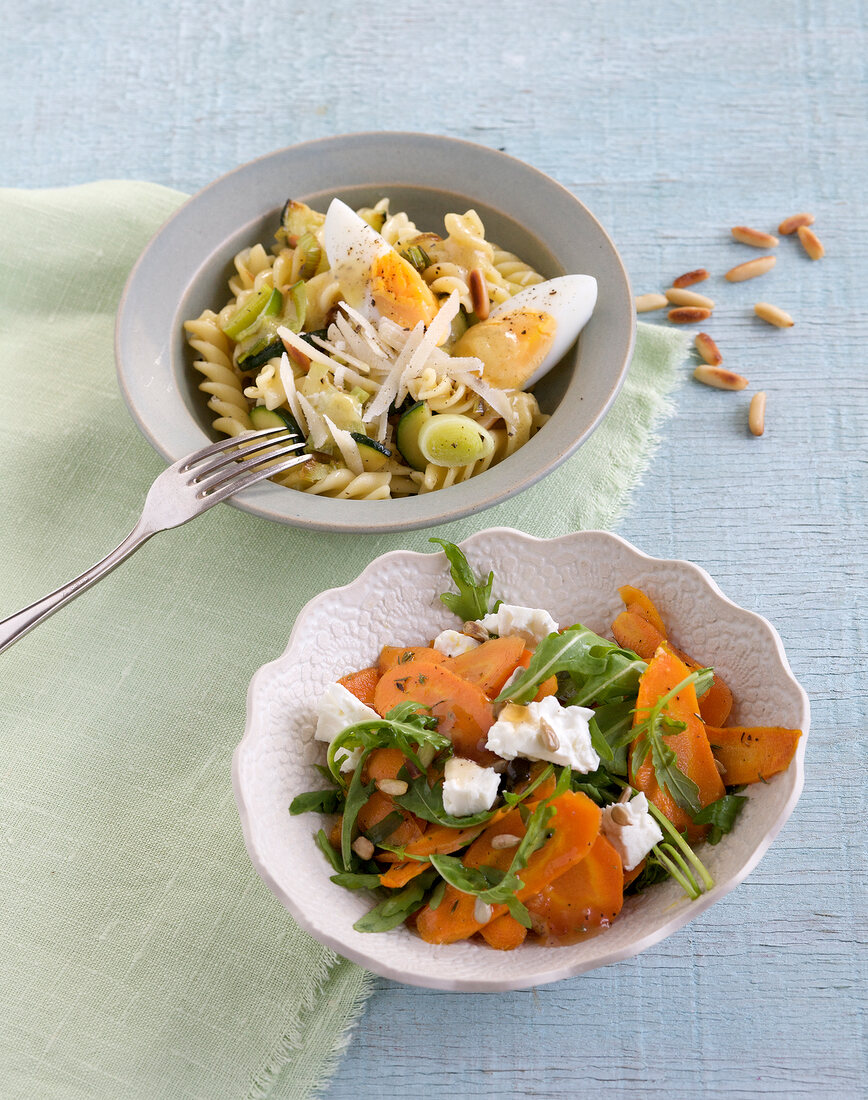 Fusilli pasta salad and carrot salad in bowls
