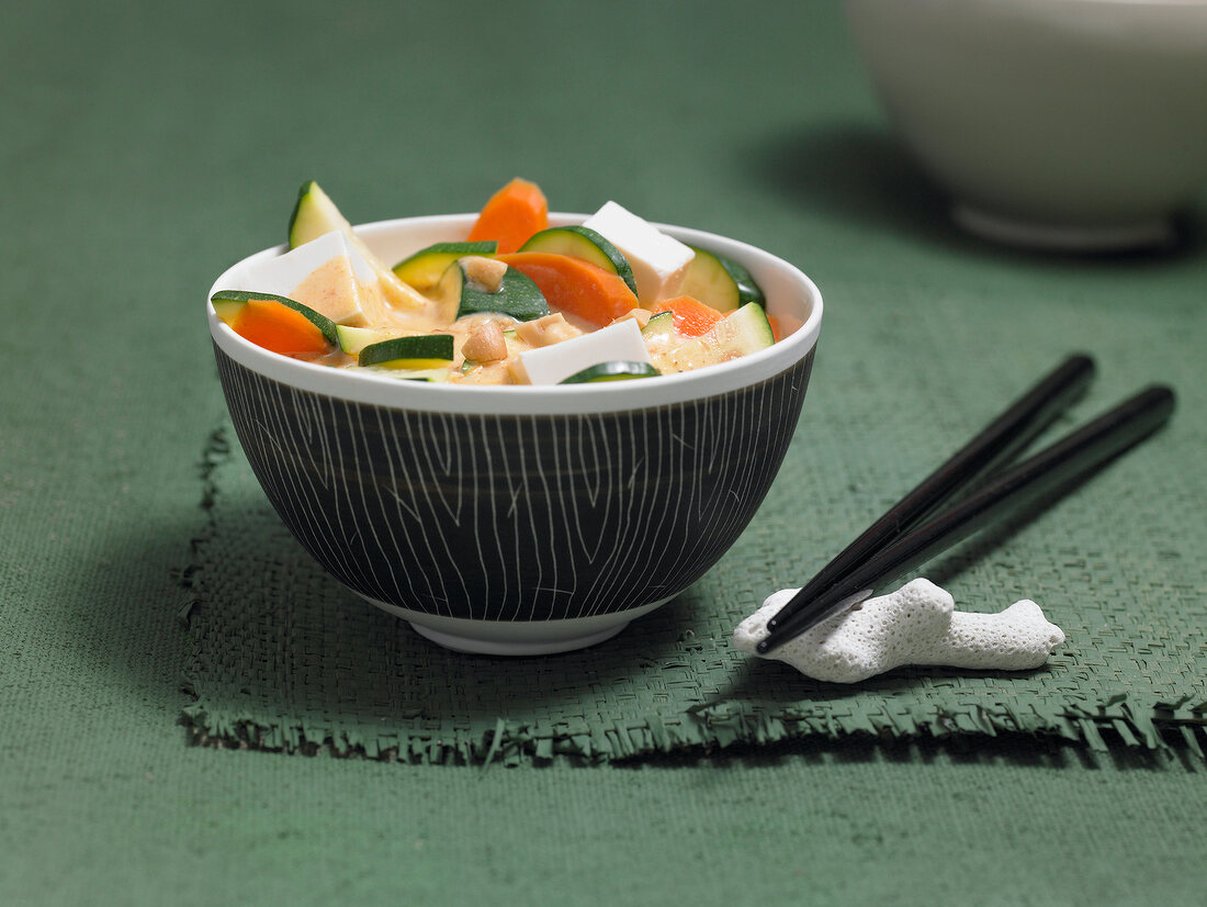 Tofu curry with carrots and zucchini in bowl