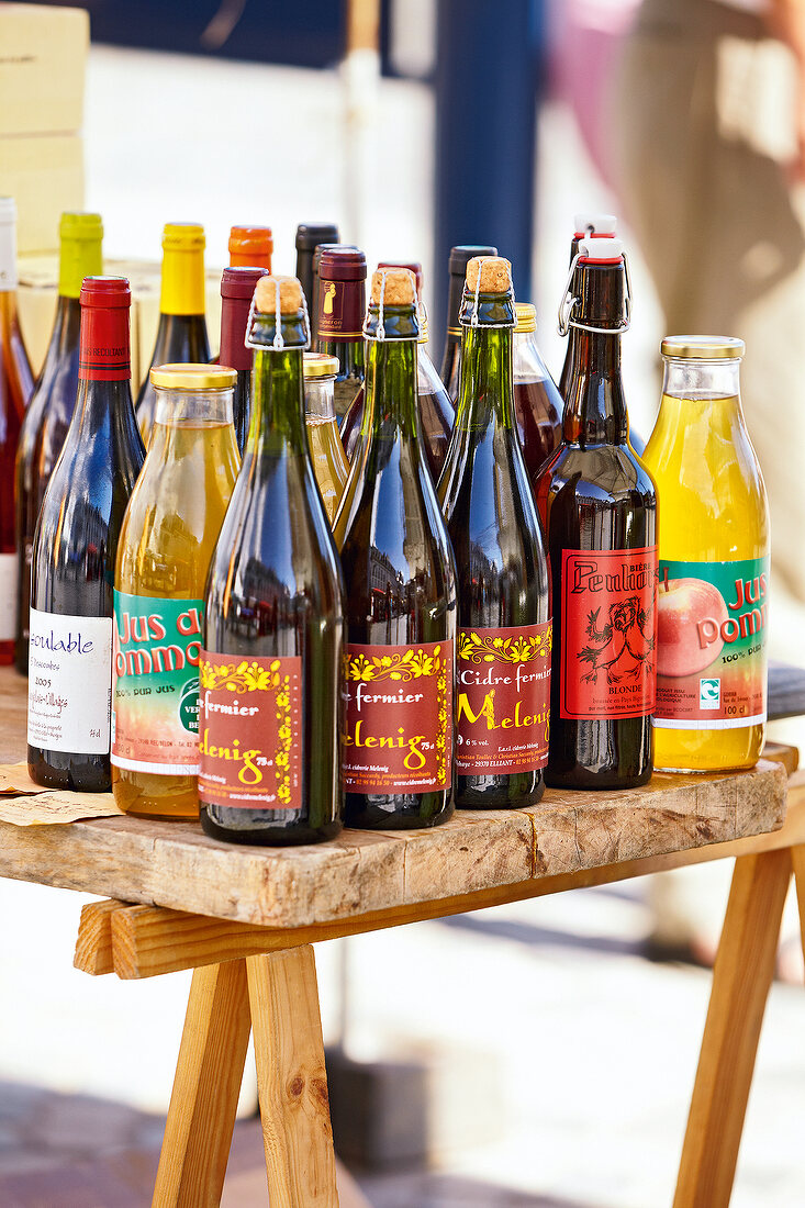 Various bottles of cider on table in market stall
