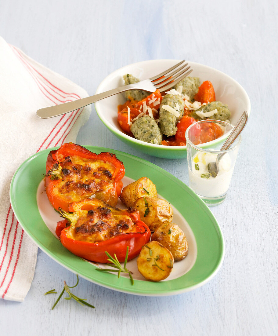 Stuffed peppers in serving dish with chard in bowl