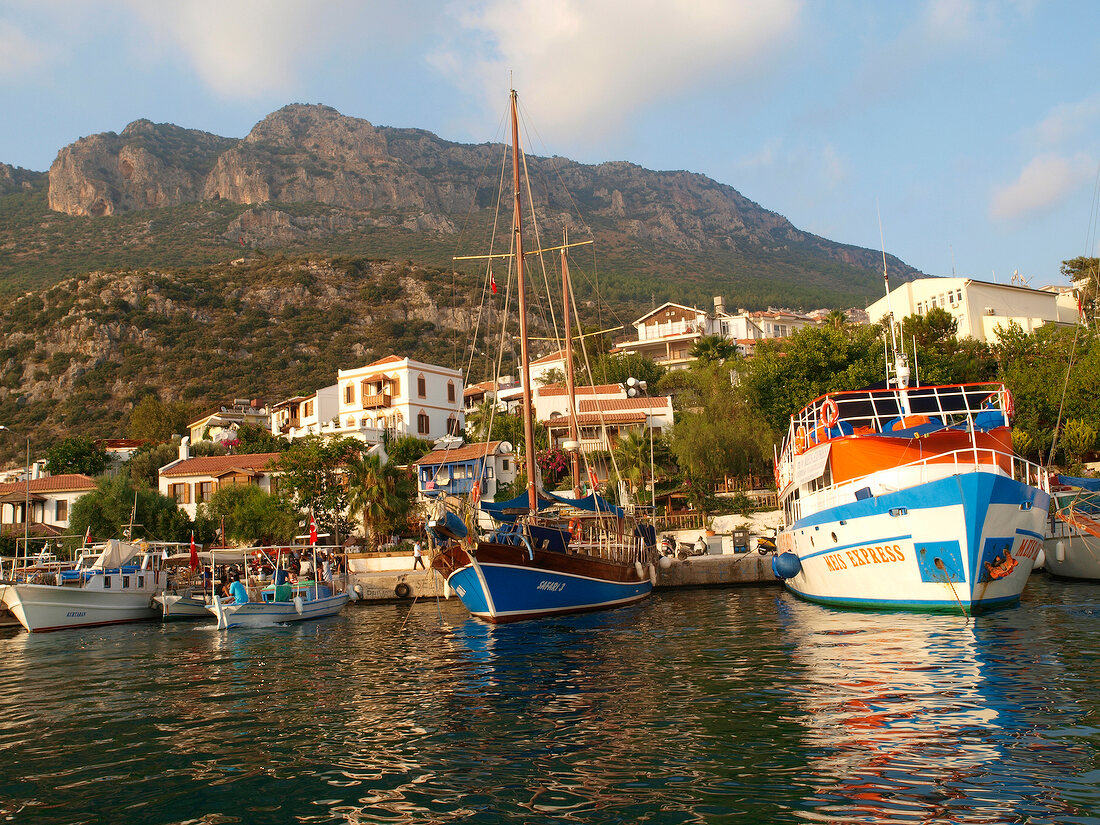 View of boats moored at harbour with mountains in background, Kas, Lycia, Antalya, Turkey