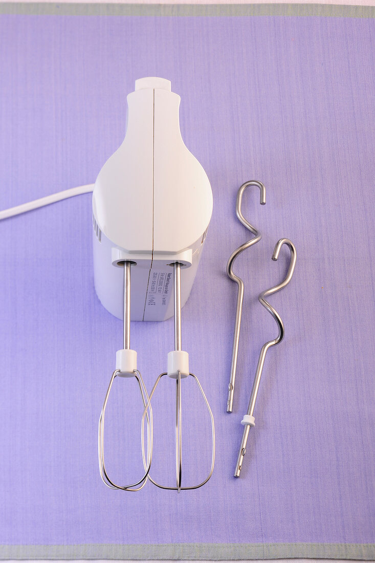 Hand mixer on purple background