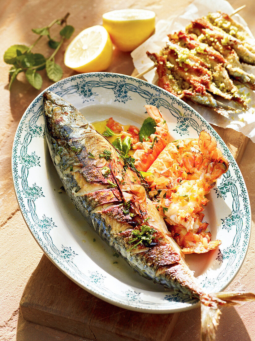 Fried mackerel with herbs and lobster on plate with sardines, France