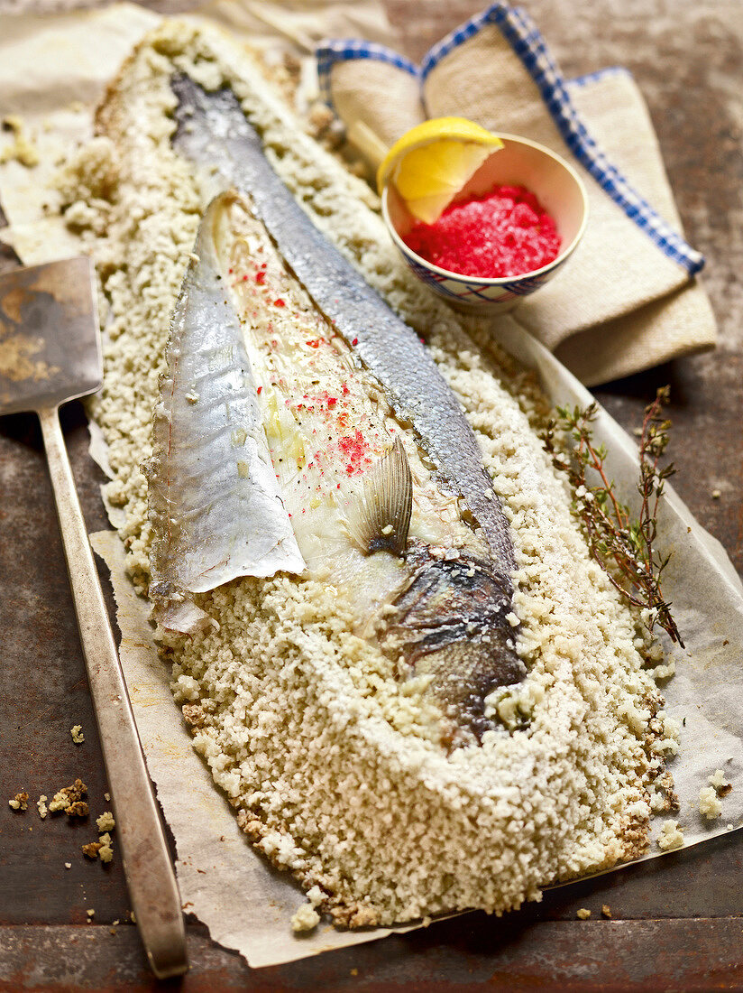 Sea bass baked in salt with raspberry powder sprinkled on it, France