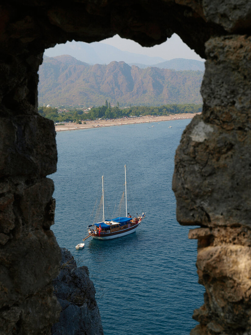 View of boat in sea from ruined city of Olympos, Lycia, Turkey