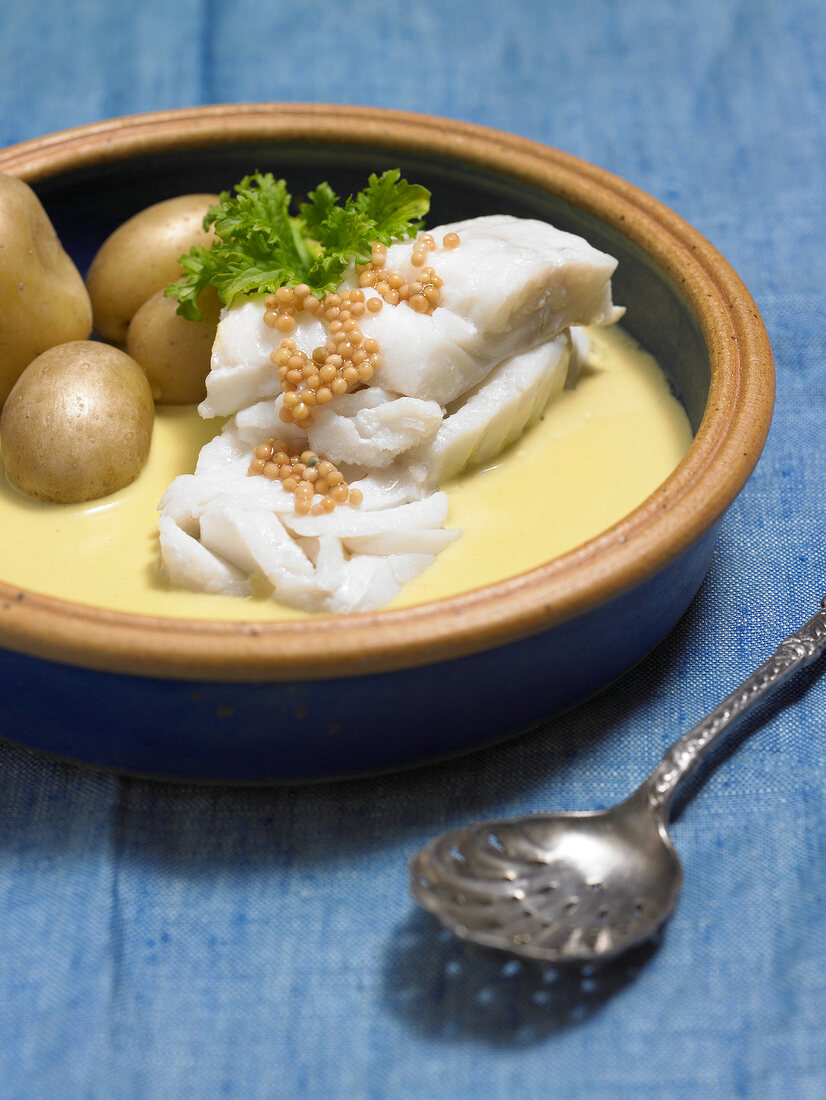 Fish with mustard cream and potatoes in bowl