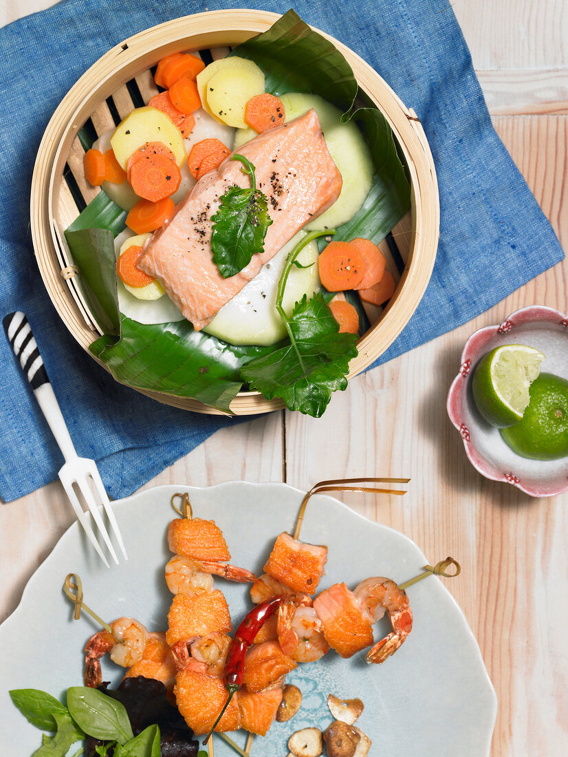 Salmon with kohlrabi in serving dish and salmon with prawn skewers on plate