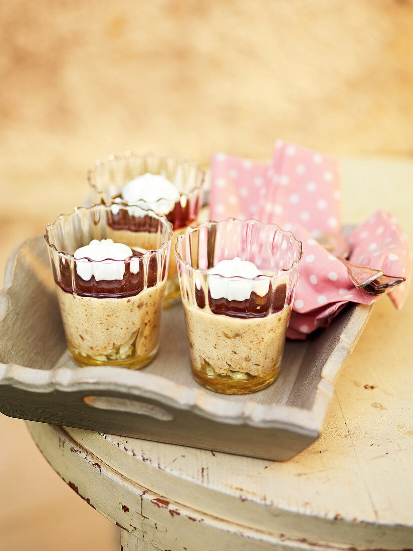 Chestnut mousse with chocolate sauce in three glasses on tray, France